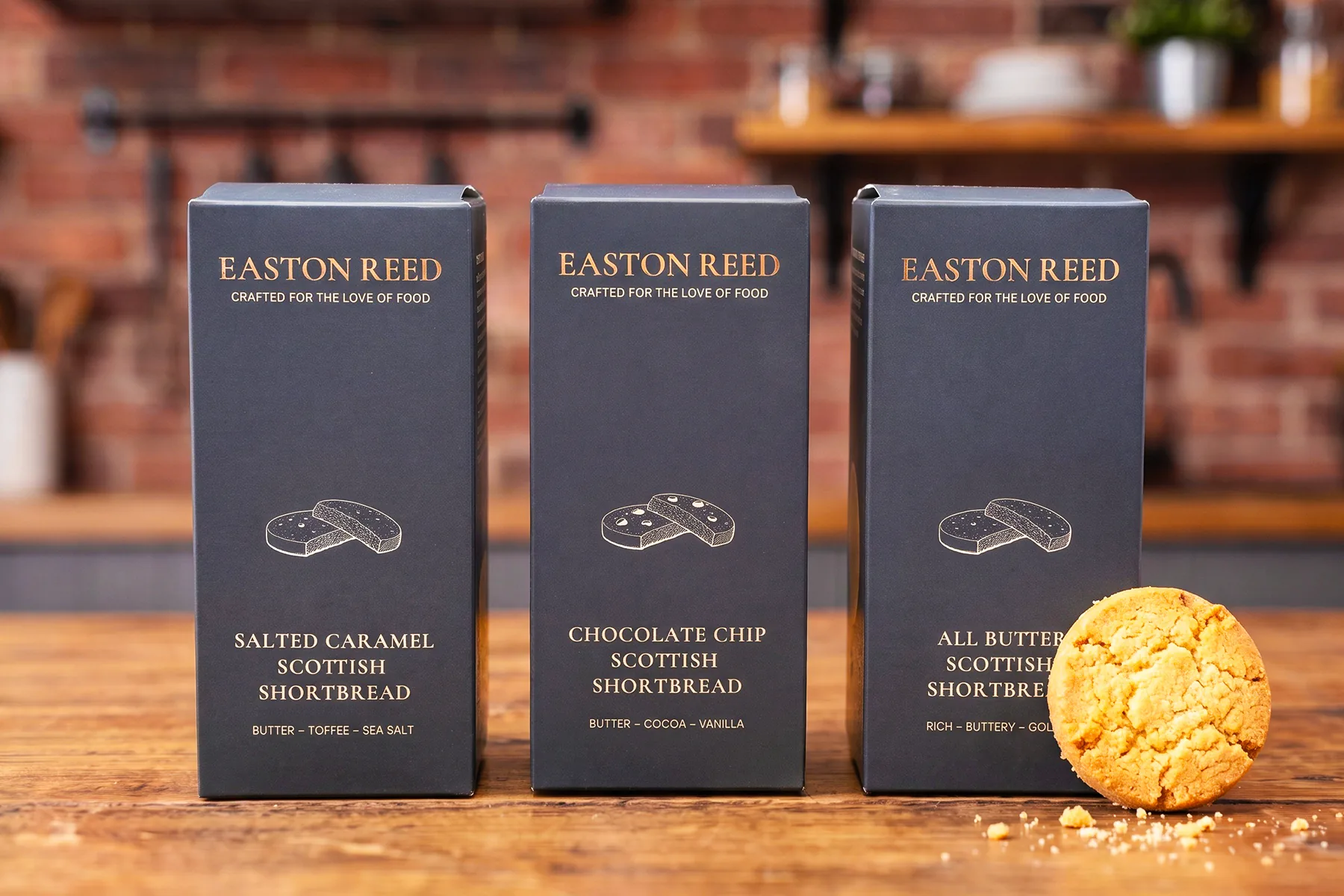 Three Easton Reed Scottish Shortbread boxes on a linen cloth with biscuits